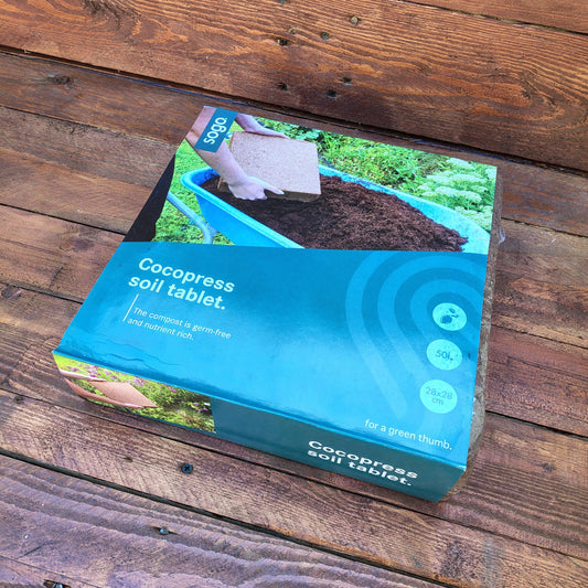 Cocopress soil tablet packaging on a wooden surface